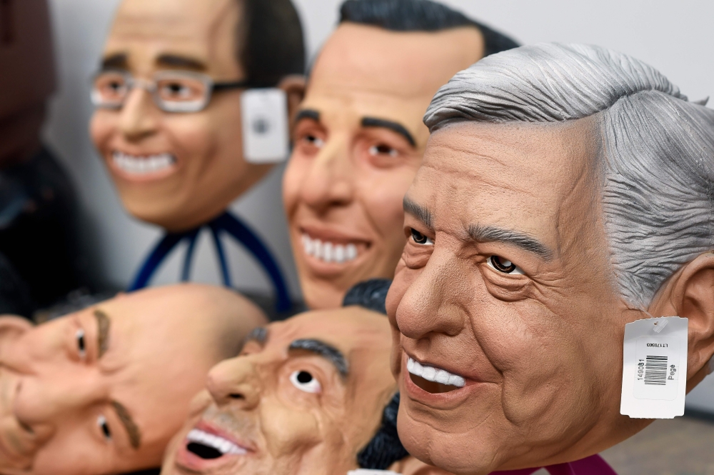A latex mask of Mexican presidential candidate Andres Manuel Lopez Obrador (R), of the MORENA party, and those of other candidates and political figures are displayed at a Rev factory in Cuernavaca, Morelos State, Mexico, on March 28, 2018. Mexico will ho