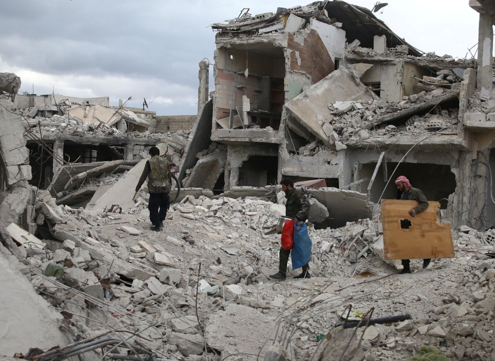 People walk on rubble of damaged buildings in the besieged town of Douma, Eastern Ghouta, in Damascus, Syria March 30, 2018. (REUTERS/Bassam Khabieh)