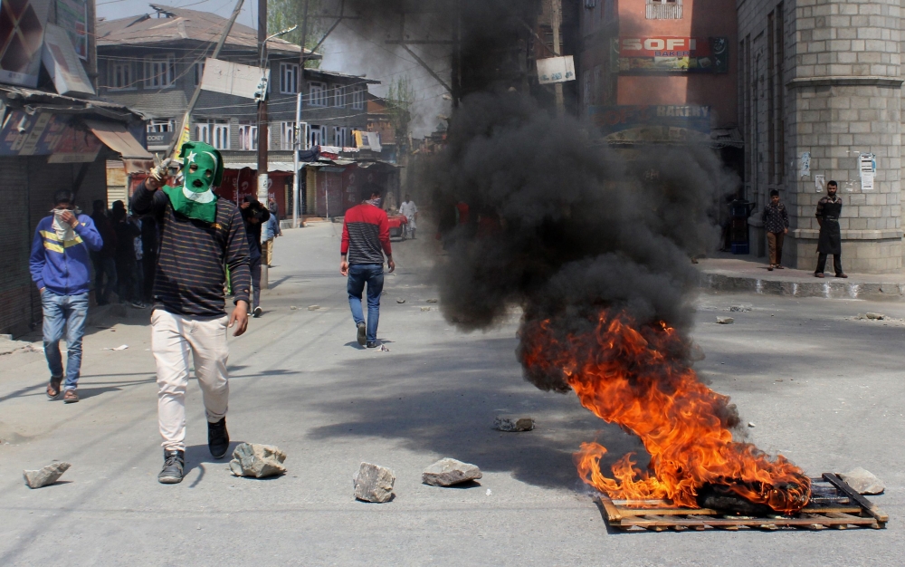 Indian Kashmiris stand along a barricaded street during unrest following gun fights between suspected militants and Indian forces in South Kashmir, in Srinagar on April 1, 2018.   AFP / HABIB NAQASH
