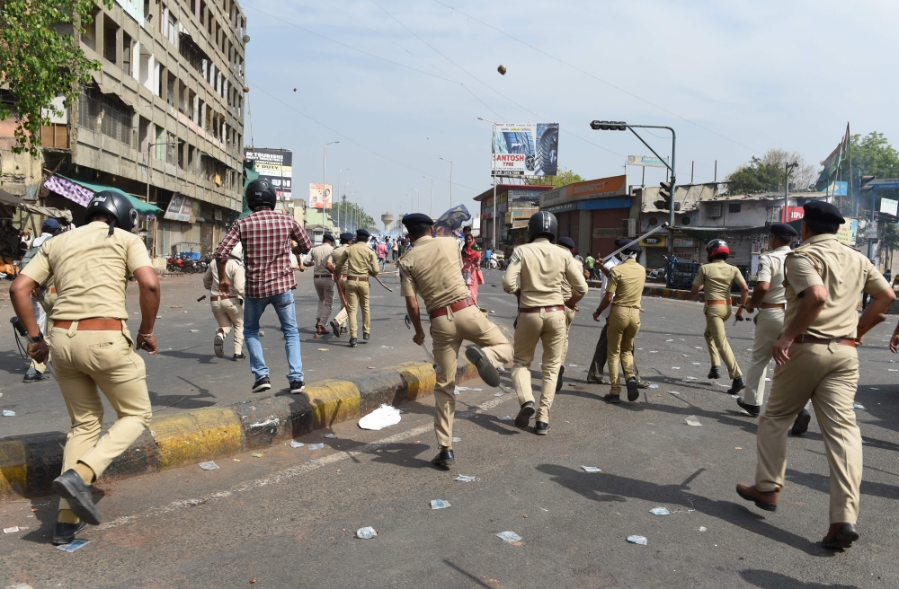 A Gujarat Police official (C) during clashes with members of the Scheduled Castes at a protest against a Supreme Court order that allegedly diluted the Scheduled Castes and Scheduled Tribes (Prevention of Atrocities) Act in Ahmedabad on April 2, 2018. AFP