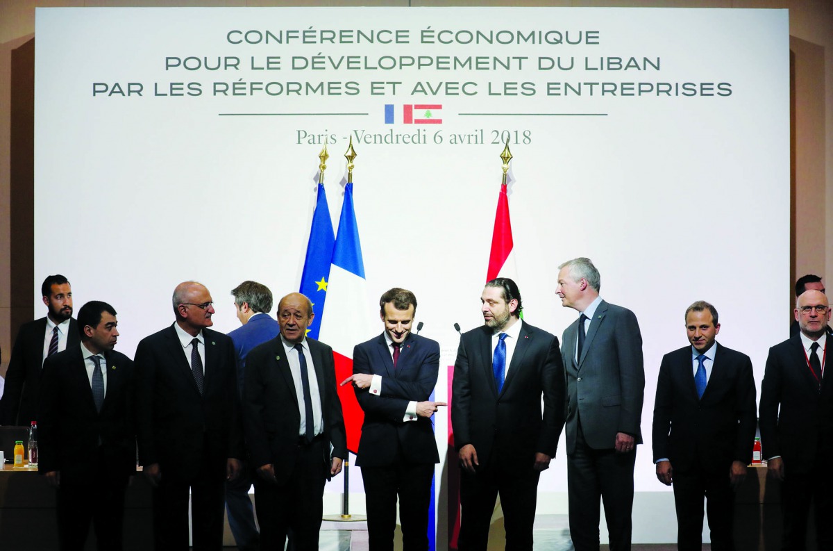 Fench President Emmanuel Macron (C) reacts during the International CEDRE Conference on April 6, 2018 in Paris. International donors are set to give the green light to a $10-billion investment plan for Lebanon at the conference in Paris, hoping to stave o