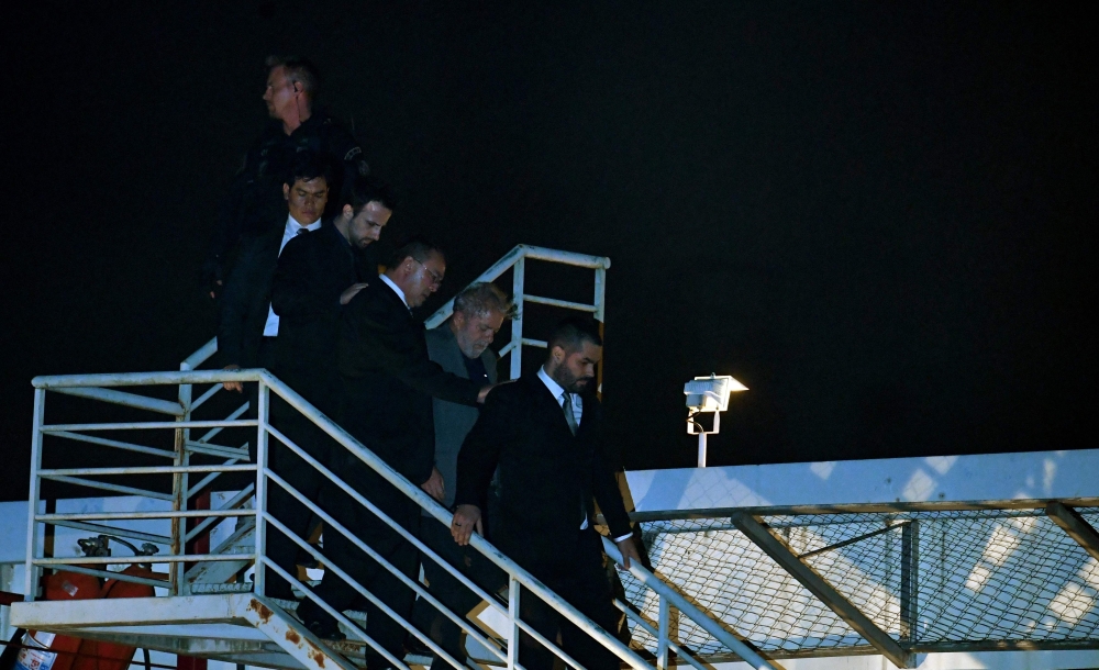 Brazilian ex-president (2003-2011) Luiz Inacio Lula da Silva (2nd R) arrives at the Federal Police headquarters where he is due to serve his 12-year prison sentence, in Curitiba, Parana State, Brazil, on April 7, 2018. AFP / MAURO PIMENTEL