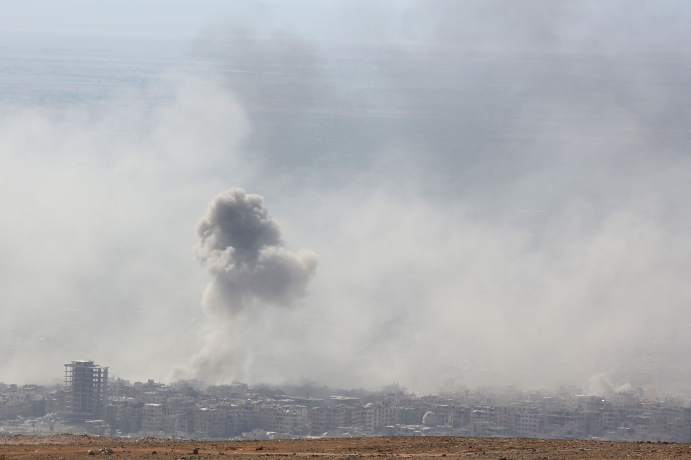Smoke billows in the town of Douma, the last opposition holdout in Syria's Eastern Ghouta, on April 7, 2018, after Syrian regime troops resumed a military blitz to pressure rebels to withdraw.  AFP / STRINGER