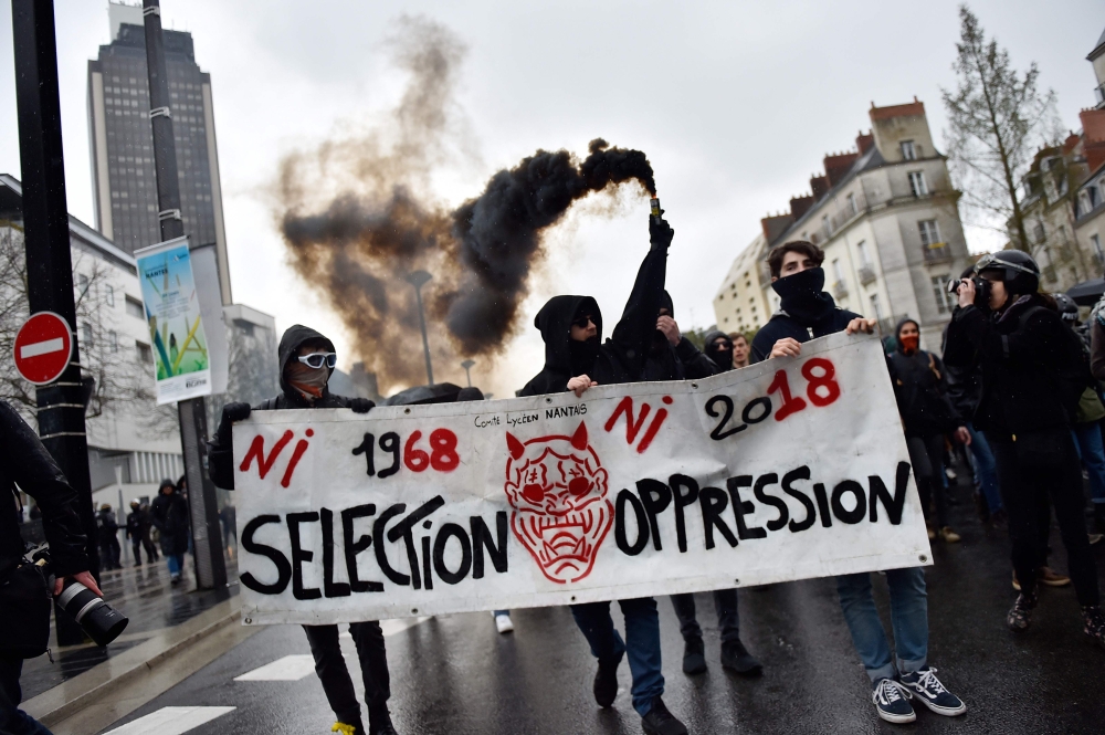 Protestors carry a banner reading 