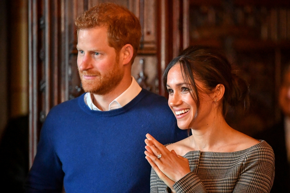 File photo of Britain's Prince Harry and his fiancee Meghan Markle watch a performance by a Welsh choir in the banqueting hall during a visit to Cardiff Castle in Cardiff, Britain, January 18, 2018. REUTERS/Ben Birchall/Pool/File Photo