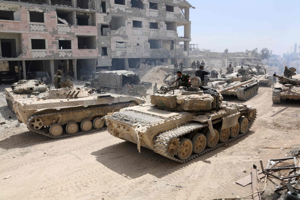 A picture taken on April 8, 2018, shows Syrian Army soldiers gathering in an area on the eastern outskirts of Douma, as they continue their fierce offensive to retake the last opposition holdout in Eastern Ghouta.   AFP / STRINGER