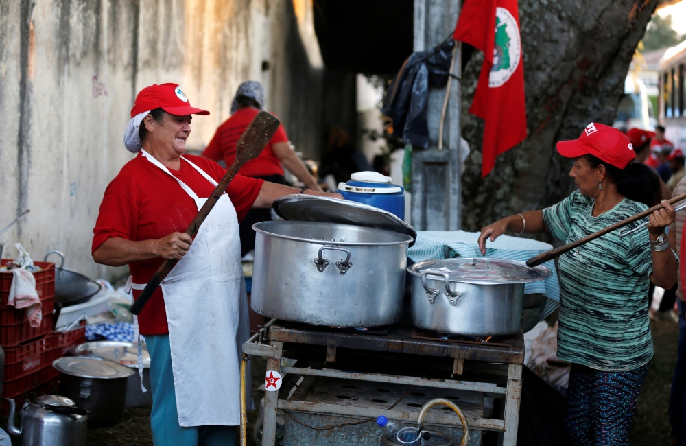 Supporters of former Brazilian President Luiz Inacio Lula da Silva cooking in a camp near the Federal Police headquarters, where Lula is imprisoned, in Curitiba, Brazil. April 9, 2018. Reuters/Rodolfo Buhrer