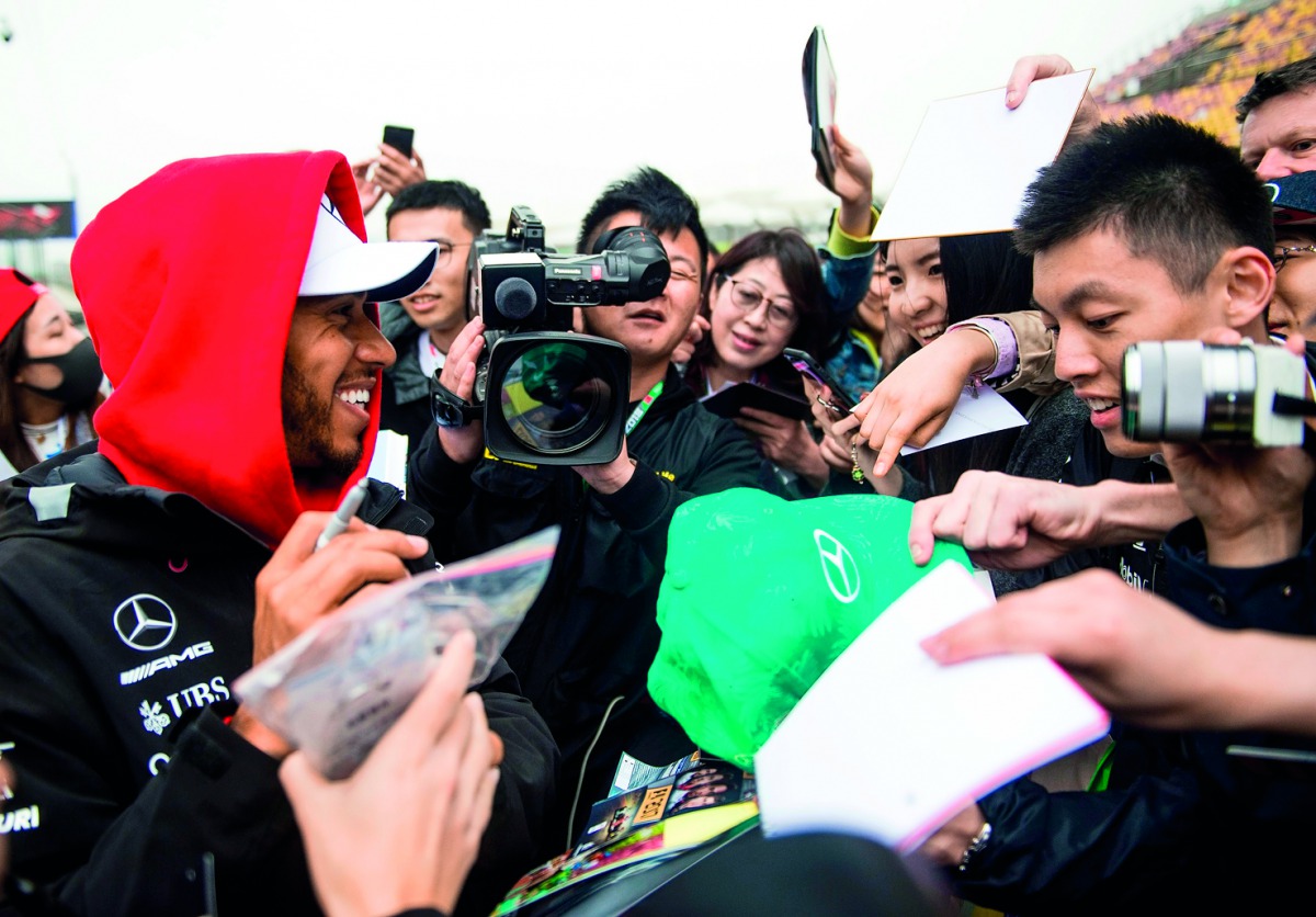 Mercedes' British driver Lewis Hamilton (L) signs autographs prior to the Formula One Chinese Grand Prix in Shanghai on April 12, 2018. AFP / Johannes Eisele