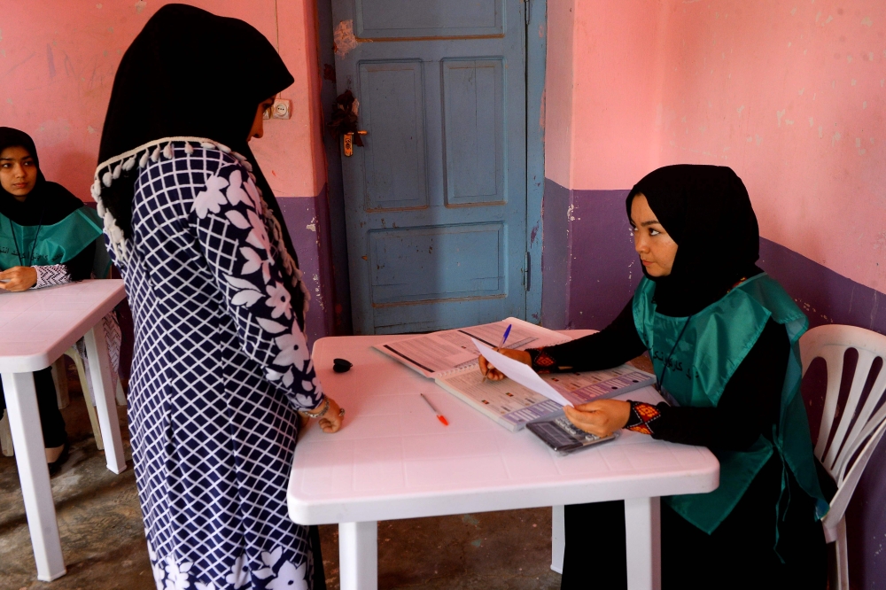 This photo taken on April 14, 2018 shows an Afghan employee of the Independent Election Commission (IEC) registering a resident at a voter registration center for the upcoming parliamentary and district council elections in Kabul. AFP / HOSHANG HASHIMI