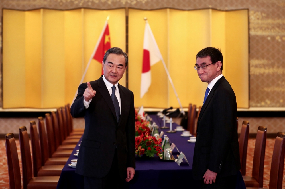 Japan's Foreign Minister Taro Kono (R) and his Chinese counterpart Wang Yi (L) arrive for their meeting in Tokyo on April 15, 2018. / AFP / POOL / Behrouz MEHRI
