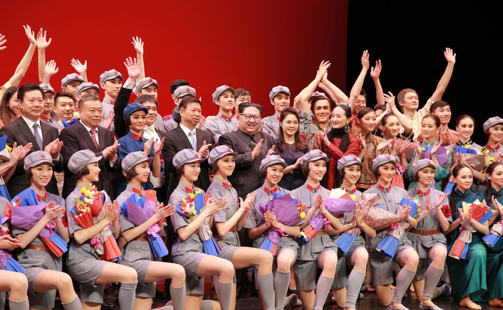 This picture from North Korea's official Korean Central News Agency (KCNA) taken on April 16, 2018 and released on April 17, 2018 shows North Korean leader Kim Jong-Un (middle 5th L) and his wife Ri Sol-Ju (middle 7th R) posing with performers of the ball