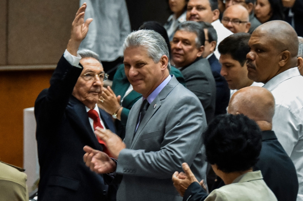 Cuban President Raul Castro (L) waves next to First Vice-President Miguel Diaz-Canel (C) during a National Assembly session that will select Cuba's Council of State ahead of the naming of a new president, in Havana on April 18, 2018.  AFP / STR
