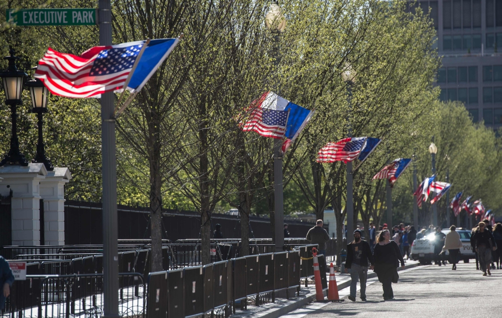 A US national flag, French flag(C) and Washington DC flag fly near the White House in Washington, DC on April 20, 2018, the week before the visit of French President Emmanuel Macron. AFP / Andrew CABALLERO-REYNOLDS