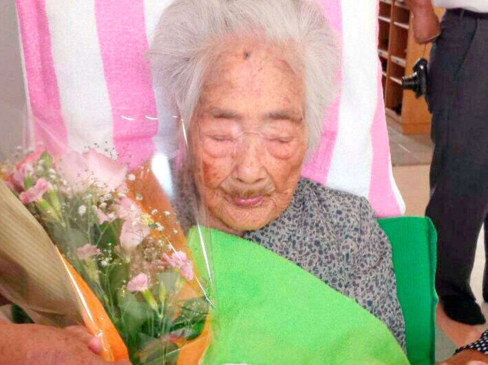 Nabi Tajima, born in 1900, holds a bouquet in Japanese southwestern island of Kikaijima, Kagoshima Prefecture, Japan, in this photo taken in 2015 and released by Kyodo.