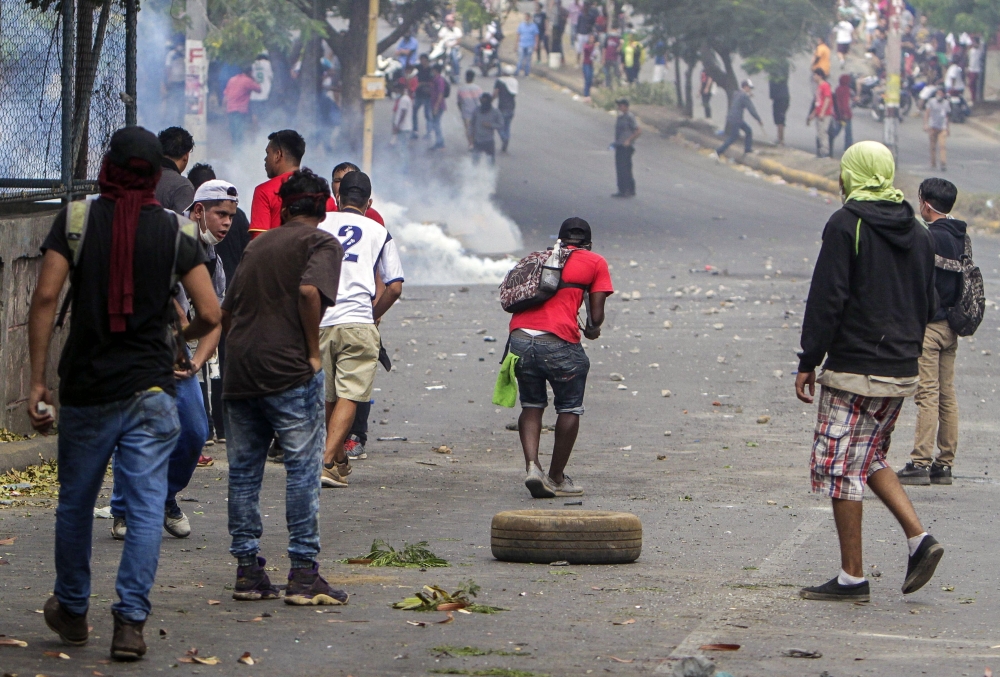 Students clash with riot police agents close to Nicaragua's Technical College during a protest against government's reforms in the Institute of Social Security (INSS) in Managua on April 21, 2018.  AFP / INTI OCON
