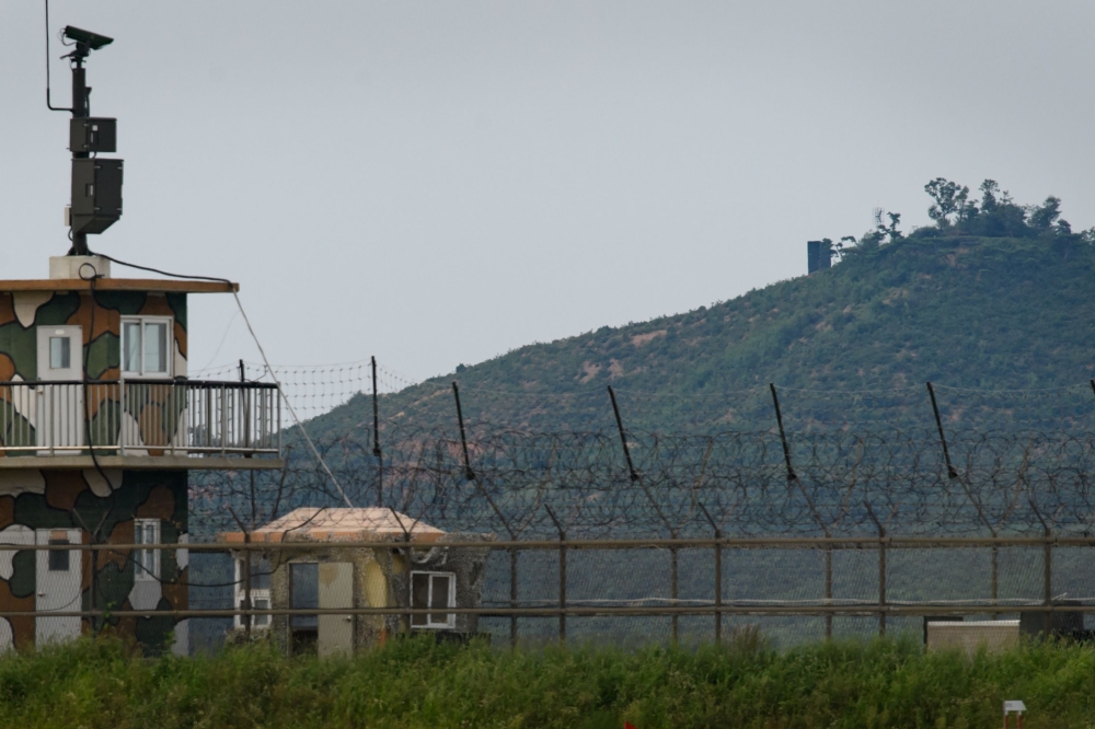 File photo of a North Korean propaganda speaker (top C) behind a South Korean military guard post (L) seen across the Demilitarized Zone (DMZ) separating the two countries from the South Korean island of Ganghwa, September 9, 2017.  / AFP / Ed JONES 