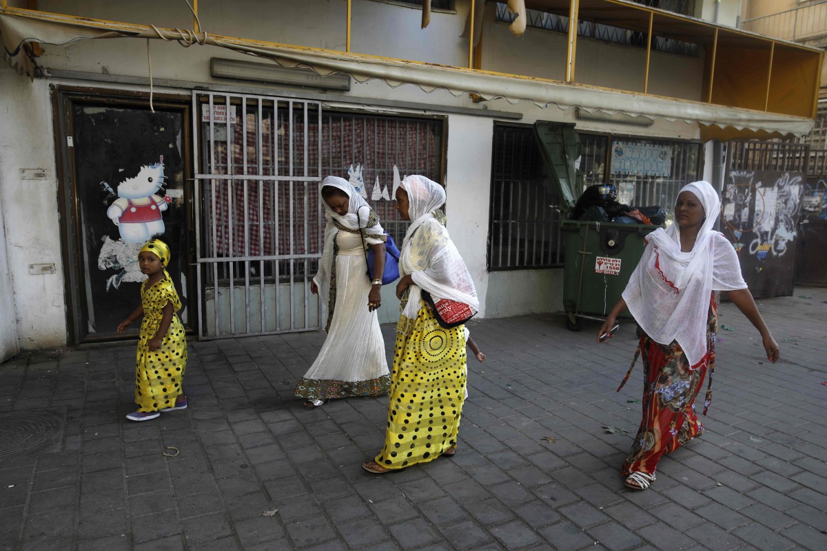 This file photo taken on September 2, 2017 shows Christian African Eritrean migrants walking outside at a makeshift church in southern Tel Aviv (AFP / Menahem Kahana) 