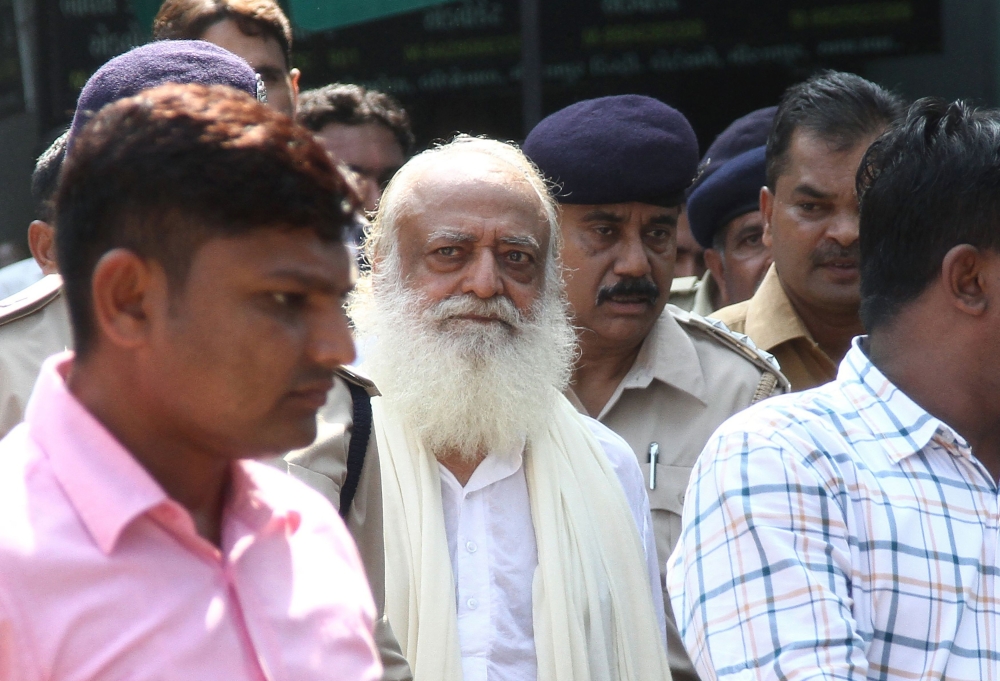 (FILES) In this file photo taken on October 15, 2013 Indian spiritual guru Asaram Bapu (C) is escorted by state police as he leaves a local court in Gandhinagar, some 30 km from Ahmedabad. AFP / SAM PANTHAKY