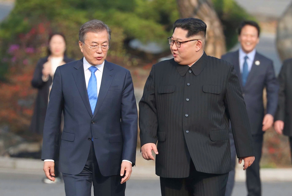 North Korea's leader Kim Jong Un (R) and South Korea's President Moon Jae-in (L) walk together after a tree-planting ceremony at the truce village of Panmunjom on April 27, 2018. AFP / Korea Summit Press Pool / Korea Summit Press Pool