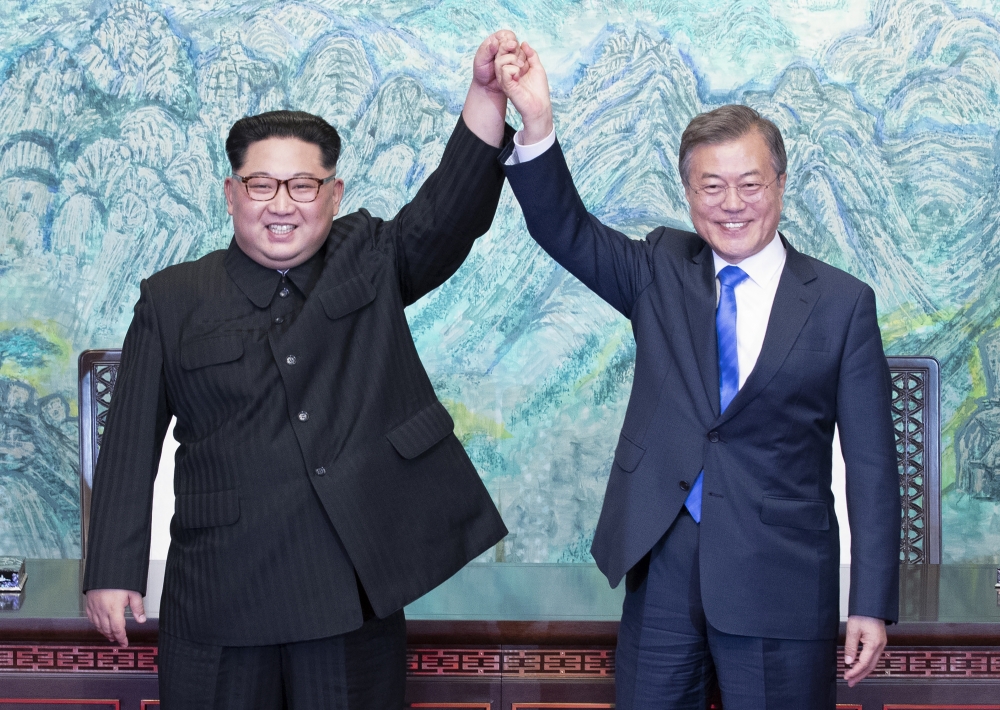 South Korean president, Moon Jae-in (R) and North Korean leader Kim Jong-un (L) are raising hands after issuing a joint statement in the Peace House building at the southern side of the truce village of Panmunjom, South Korea on April 27, 2018. Kim Jong-u