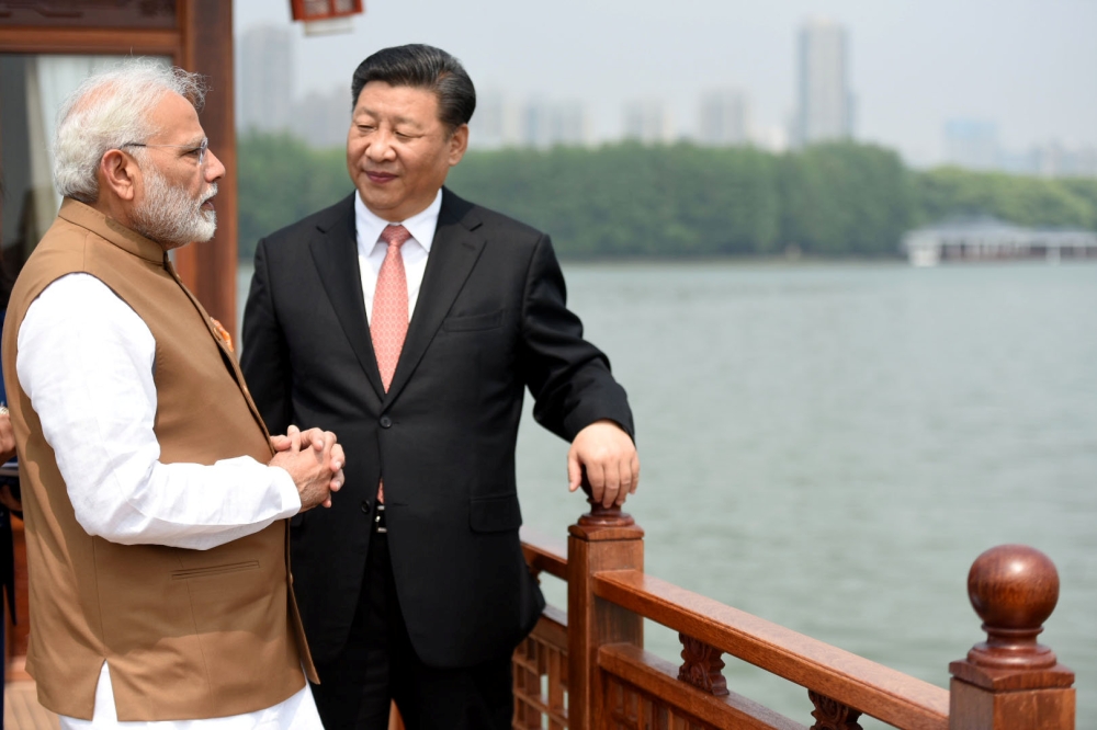 India's Prime Minister Narendra Modi speaks with Chinese President Xi Jinping as they take a boat ride on the East Lake in Wuhan, China, April 28, 2018. India's Press Information Bureau/Handout via REUTERS 