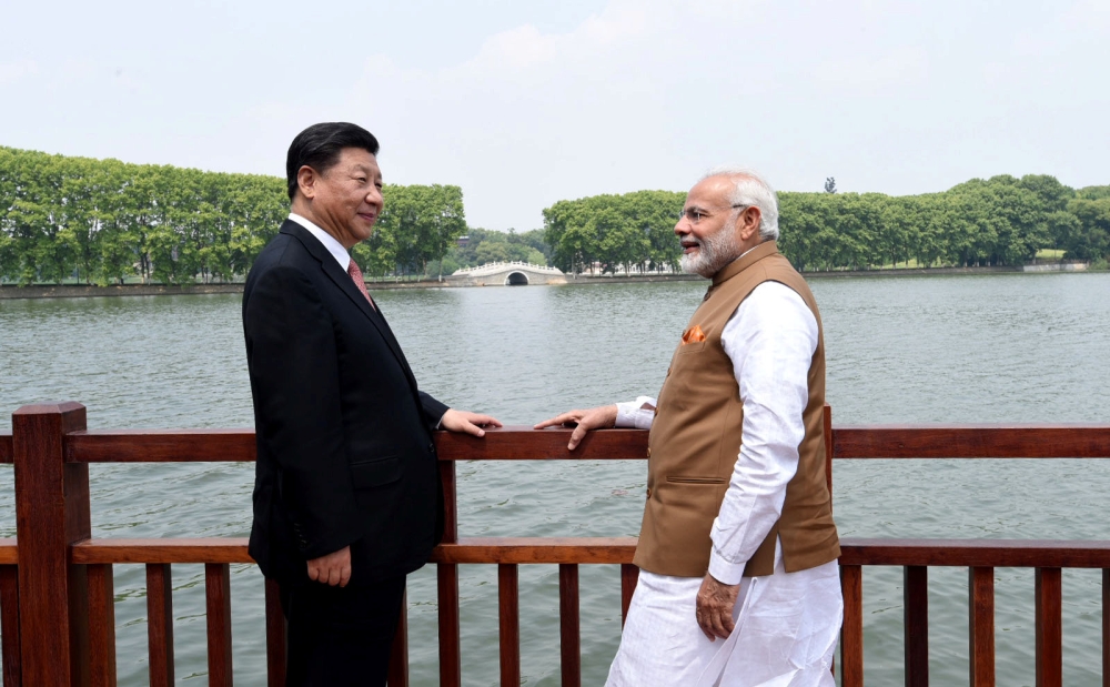 Chinese President Xi Jinping and India's Prime Minister Narendra Modi speak as they walk along the East Lake in Wuhan, China, April 28, 2018.
