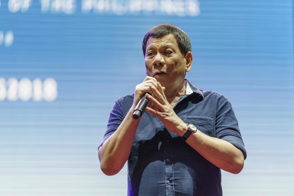 Philippine President Rodrigo Duterte (C) speaks to members of the Philippine community during a gathering in Singapore on April 28, 2018. President Duterte is in Singapore to attend the ASEAN Summit meeting on April 28. / AFP / NICHOLAS YEO