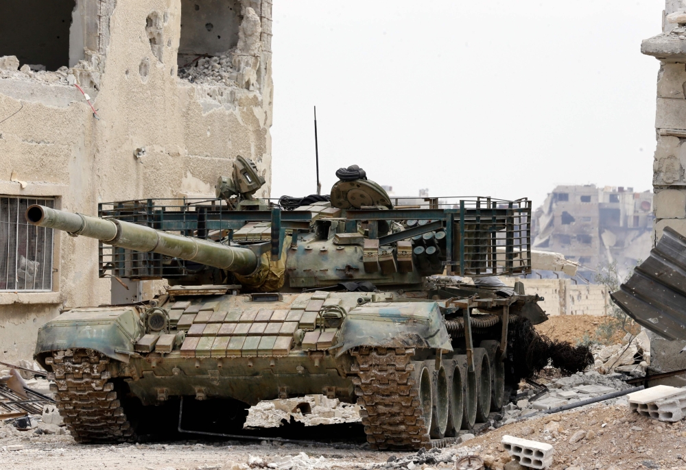 A picture taken on April 29, 2018, during a government guided tour in Damascus' southern al-Qadam neighbourhood, shows a Syrian army tank parked in a street during regime shelling targeting Islamic State (IS) group positions in Yarmuk, a Palestinian refug