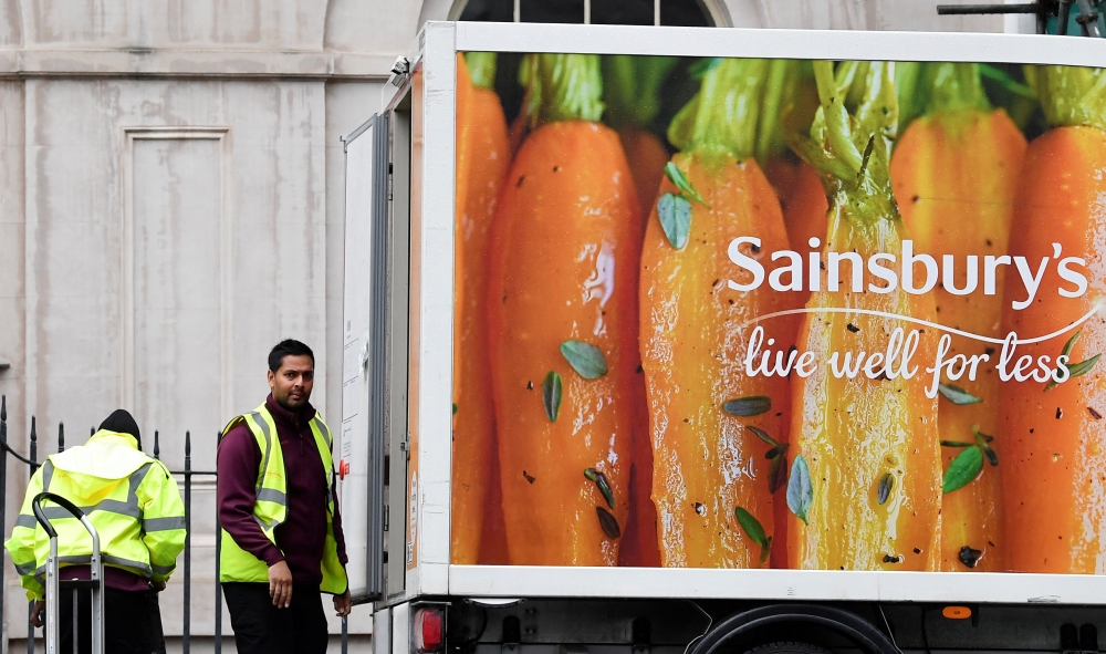 Workers unload a Sainsbury's home delivery van in central London, Britain, April 30, 2018. REUTERS/Toby Melville