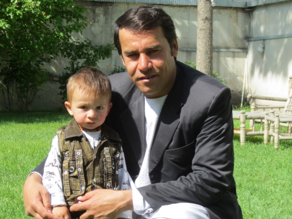 This photo taken in 2013 shows Agence France-Presse (AFP) photographer Shah Marai posing for a picture with one of his young sons, in Kabul. AFP / Ben Sheppard