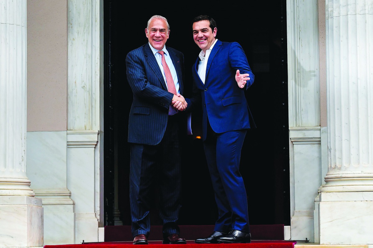 Greek Prime Minister Alexis Tsipras (R) welcomes Organization for Economic Co-operation and Development (OECD) Secretary General Angel Gurria (L) before their talks in Athens on April 30, 2018. AFP / Angelos Tzortzinis
