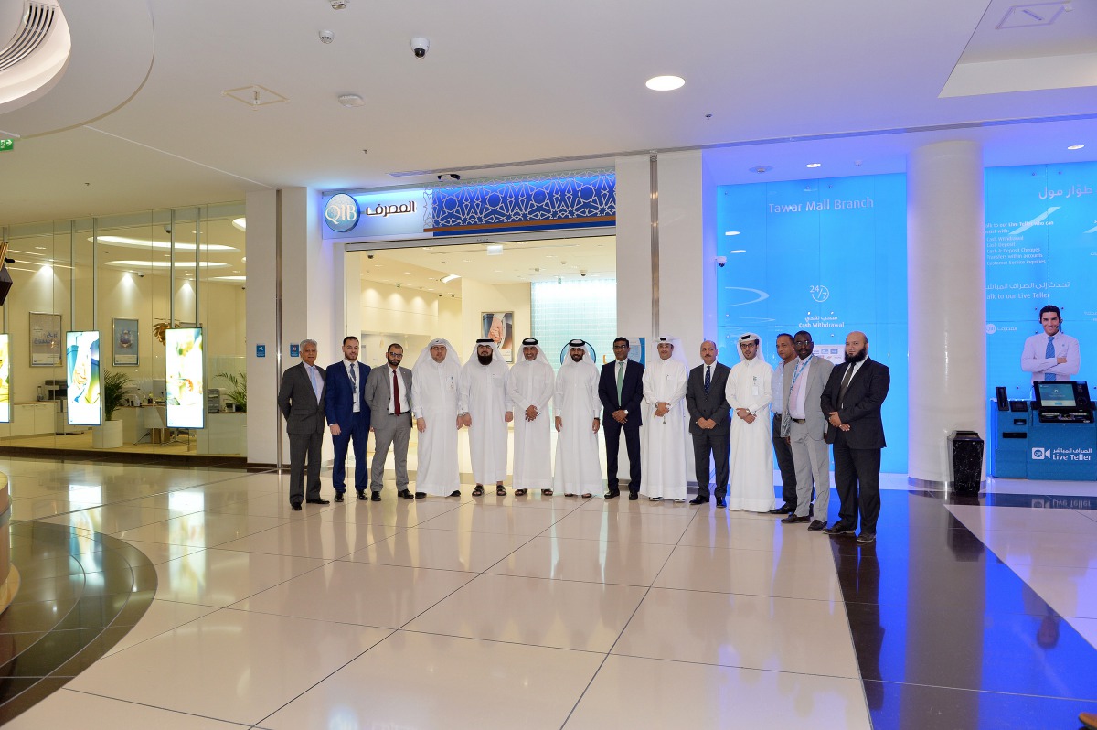 QIB Executive Management and staff members pose in front of the new branch at Tawar Mall.