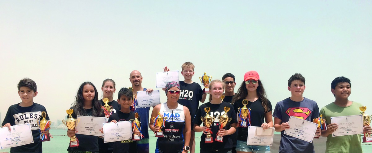 The podium winners of the Swim for a Cause open water swimming challenge, organised by Sharq Village & Spa, at Sharq Village & Spa Beach, pose for a photograph.