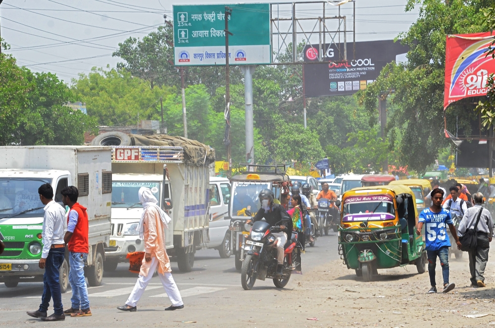 Indian commuters drive along a busy road as pedestrians try to cross a zebra crossing in the city of Kanpur of the northern Indian state of Uttar Pradesh on May 2, 2018.  AFP