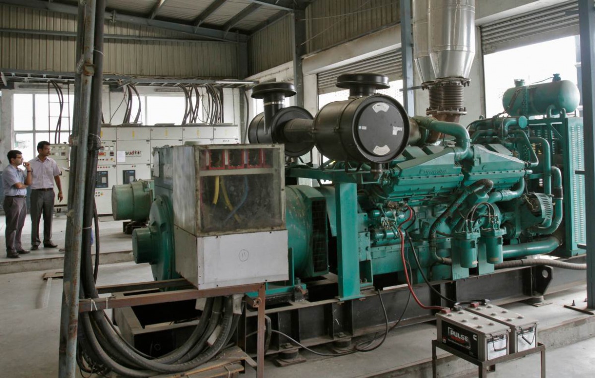Employees stand next to a power backup generator run by diesel at the Kei Industries, one of India's leading electrical equipment manufacturers at the industrial estate of Bhiwadi, in the western Indian state of Rajasthan August 6, 2012. Reuters/B Mathur