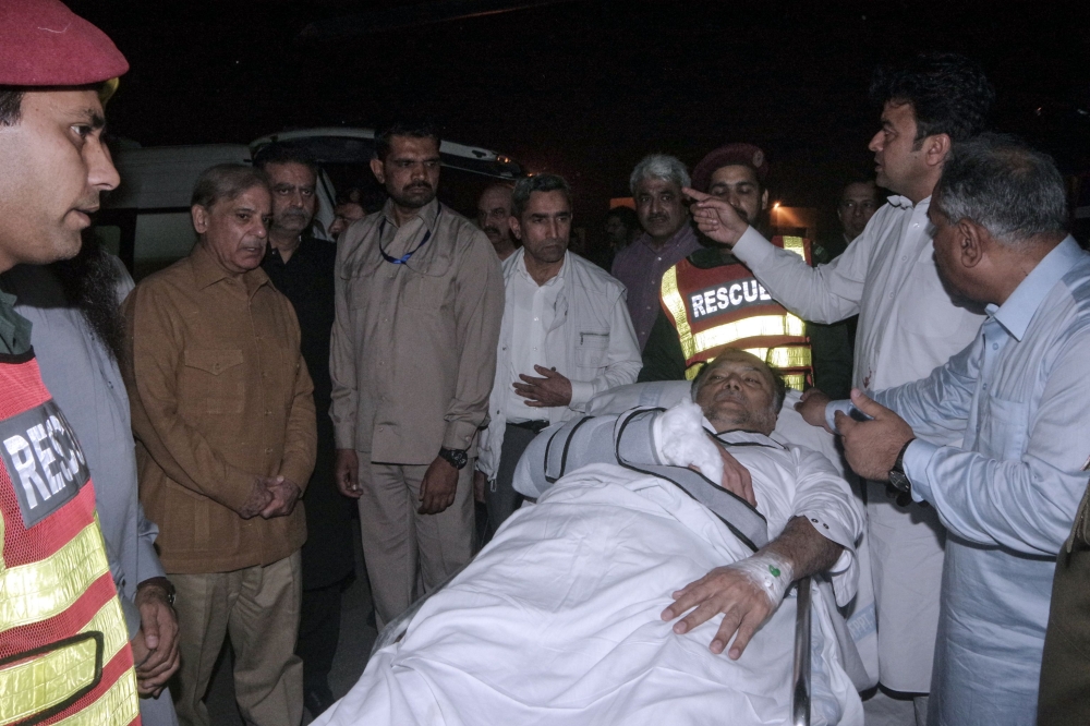 In this handout photograph released by the Press Information Department (PID) Punjab on May 6, 2018, injured Pakistan's Interior Minister Ahsan Iqbal (C) is evacuated from a helicopter on their arrival in Lahore. 
