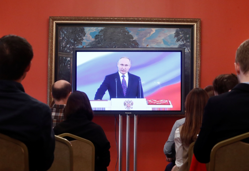 Journalists watch a ceremony to inaugurate Vladimir Putin as President of Russia at a press centre in Moscow, Russia May 7, 2018. Reuters/Sergei Karpukhin