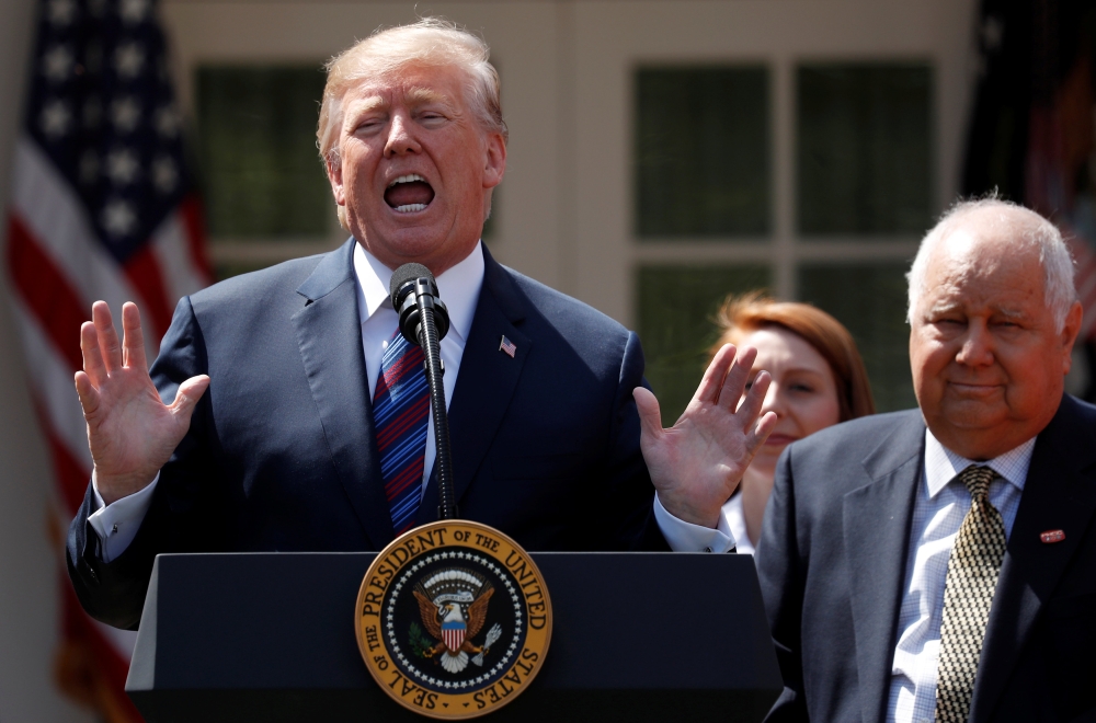 FILE PHOTO: U.S. President Donald Trump gives remarks on tax cuts for American workers as Richard Kerzetski of Universal Plumbing, North Las Vegas, Nevada, listens during an event in the White House Rose Garden in Washington, U.S., April 12, 2018. REUTERS