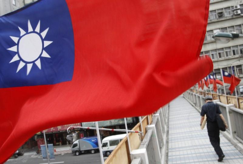 A man walks past a row of Taiwan's national flags in Taipei, October 14, 2011. REUTERS/Pichi Chuang
