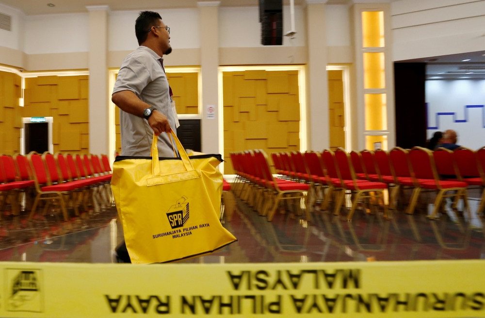 Electoral worker carries ballot boxes at the collation centre after the general election, in Petaling Jaya, Malaysia, May 9, 2018. REUTERS/Lai Seng Sin
