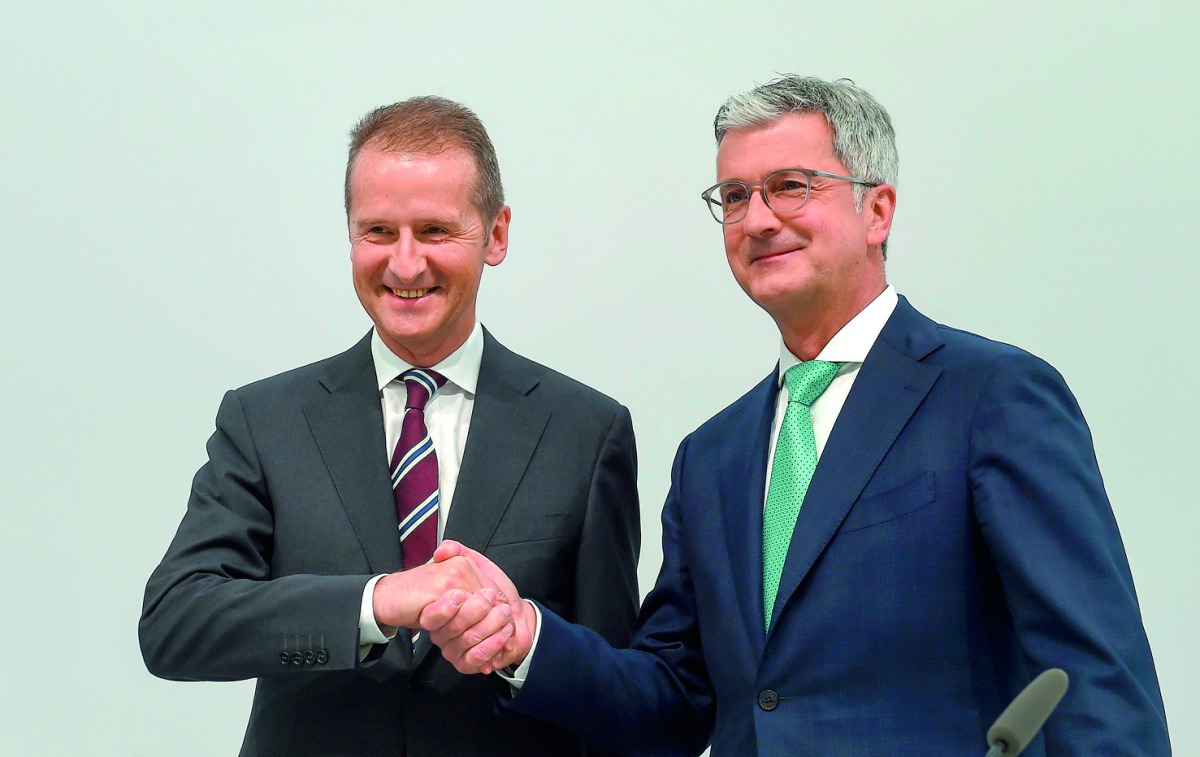 German carmaker Audi CEO Rupert Stadler (R) and Herbert Diess, chairman of the Audi supervisory board and CEO of carmaker Volkswagen (VW), shake hands prior to the Audi AG general meeting in Ingolstadt, southern Germany, on May 9, 2018. AFP / Christof Sta