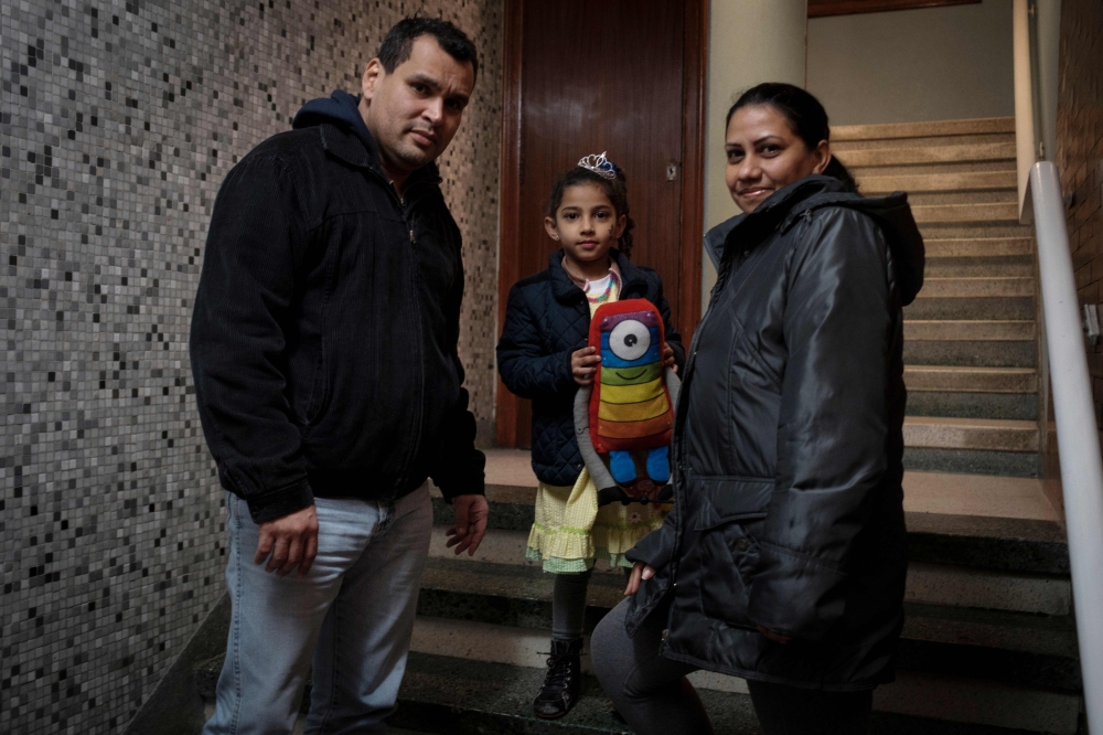 Venezuelans Fernando Sabatino (L), his wife Francis Fernandez (R) and their daughter Danyelys pose in Vigo, northwestern Spain, on March 14, 2018. / AFP / Miguel Riopa 