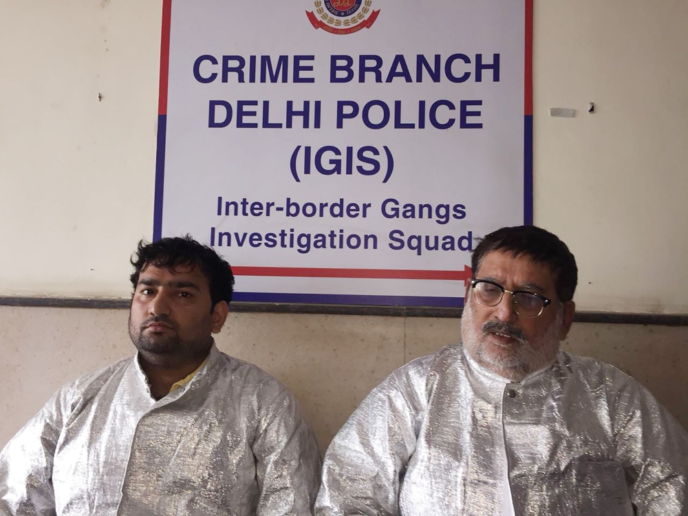 Two men dressed in 'space suits' who were arrested for alleged fraud after claiming to work for NASA are presented at a police station in New Delhi on May 9, 2018. AFP photo / Delhi Police