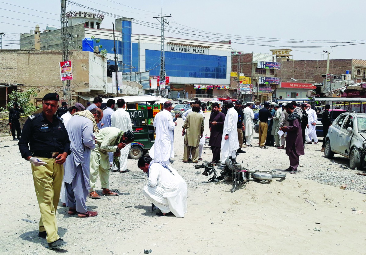 Policemen and security officers gather to collect evidence at the site of a blast, after a motorcycle exploded near a bus terminal in Bannu, Pakistan May 11, 2018. Reuters/Zahid Mohammad