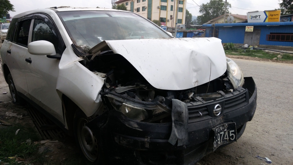 A wrecked car is pictured during clashes between the military and Ta'ang National Liberation Army (TNLA), one of several insurgent groups fighting for more autonomy in the north, in Muse on May 12, 2018. / AFP / - 