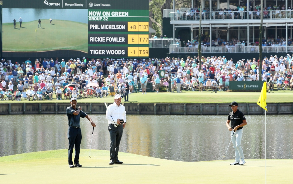 (L-R) Tiger Woods, Phil Mickelson and Rickie Fowler of the United States stand on the 17th green during the second round of THE PLAYERS Championship on the Stadium Course at TPC Sawgrass on May 11, 2018 in Ponte Vedra Beach, Florida. Jamie Squire/Getty Im