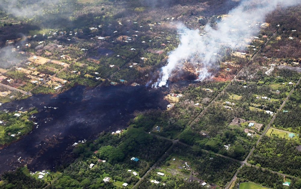 Smoke and volcanic gases rise as lava cools in the Leilani Estates neighborhood, in the aftermath of eruptions and lava flows from the Kilauea volcano on Hawaii's Big Island, on May 11, 2018 in Pahoa, Hawaii. Mario Tama/AFP