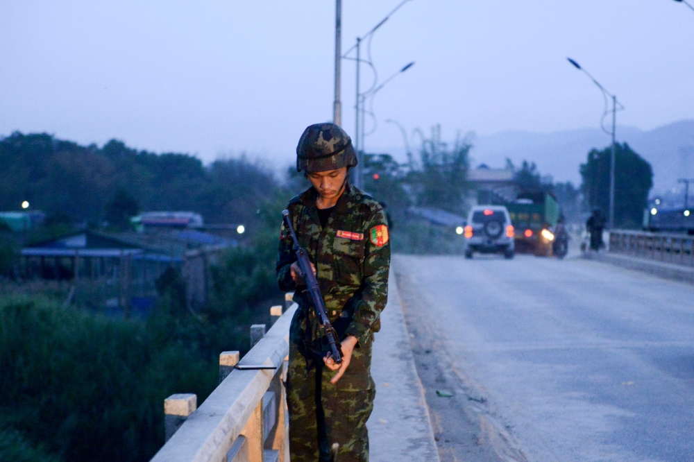 This picture taken on May 12, 2018 shows an army-linked militiaman securing a bridge in Muse. AFP