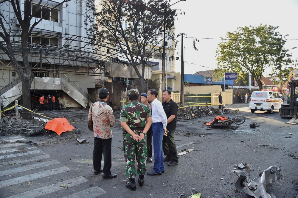 Handout photo released by the Presidential Palace shows Indonesia's President Joko Widodo (2nd R) visiting the scene of a suicide attack outside the Central Pantekosta church in Surabaya, May 13, 2018 . AFP PHOTO / Presidential Palace