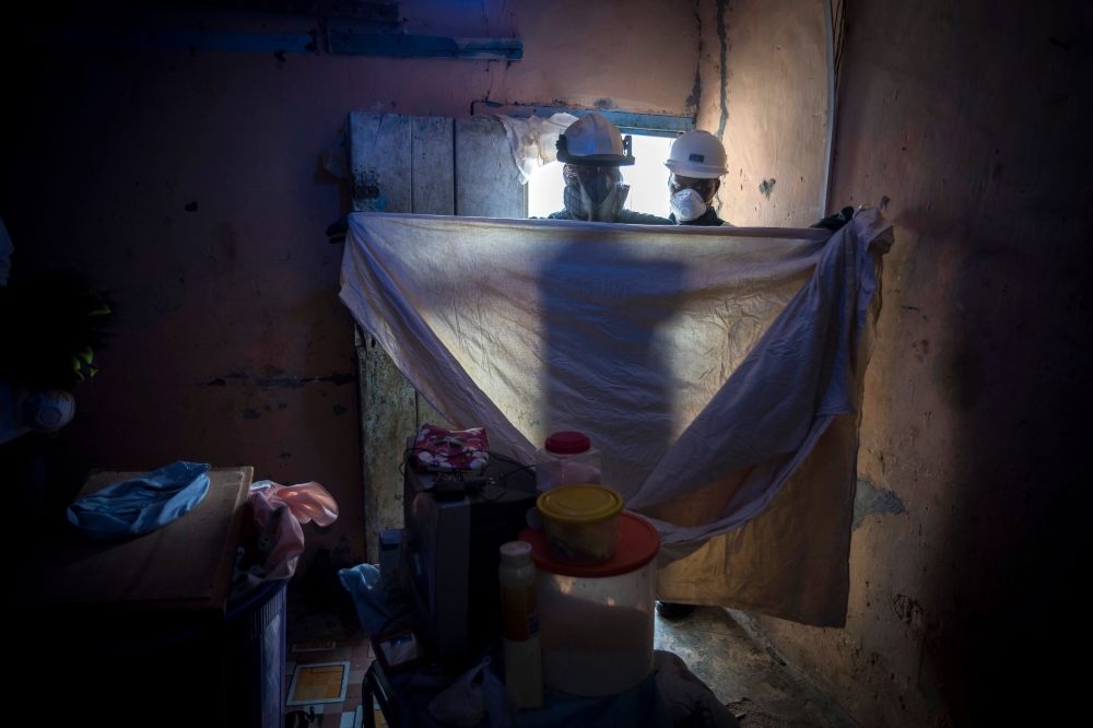Bismark Owusu, a worker of Anglogold Ashanti Malaria Ltd covers furnitures before to spray the walls of a house with insecticide against mosquitos on May 2, 2018 in Adansi Domeabra, near Obuasi, Ashanti Region. AFP / CRISTINA ALDEHUELA